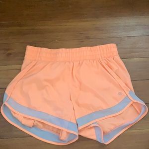 Athleta women’s running shorts in orange color.